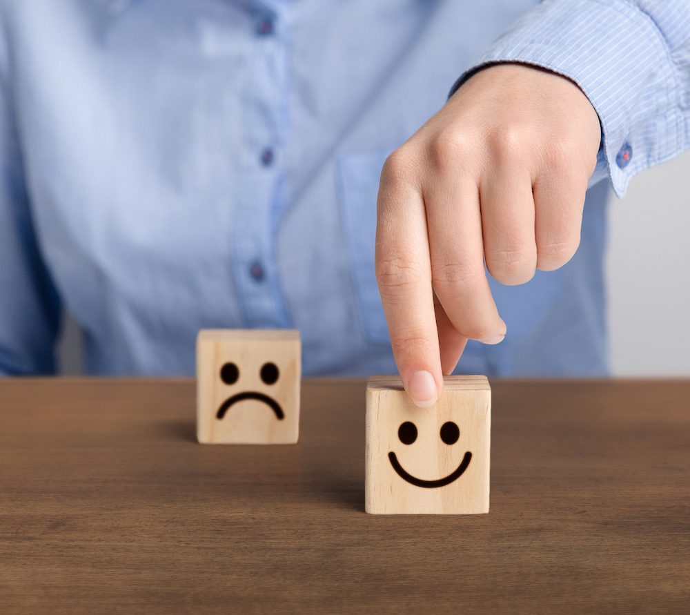 The best excellent business services rating. Hand of a businessman chooses a smiley face on wood block cube, panorama, copy space